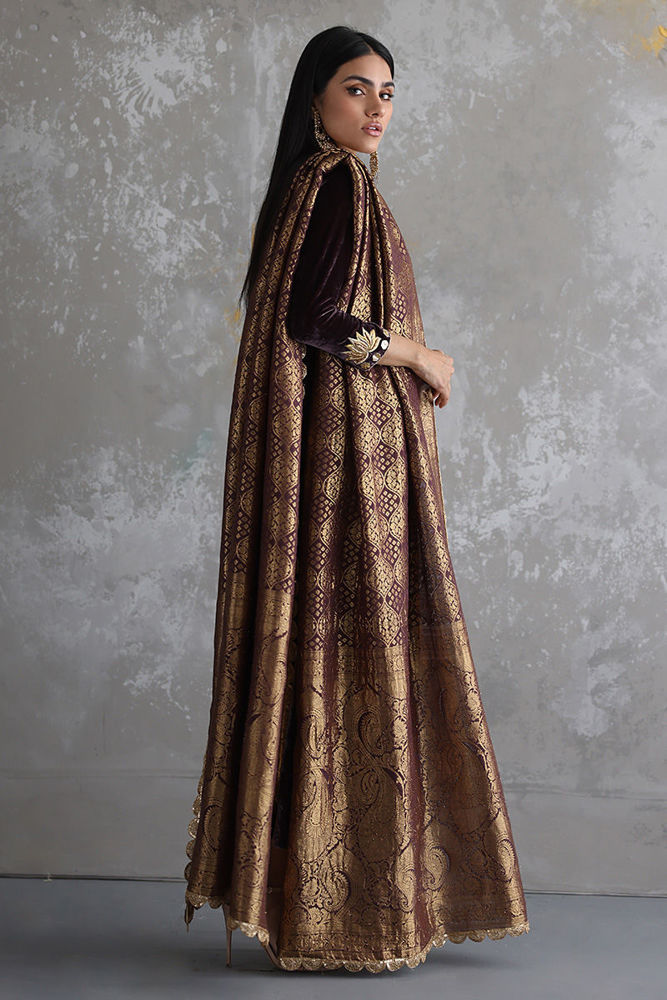 Woman wearing a long, patterned dress against a gray background