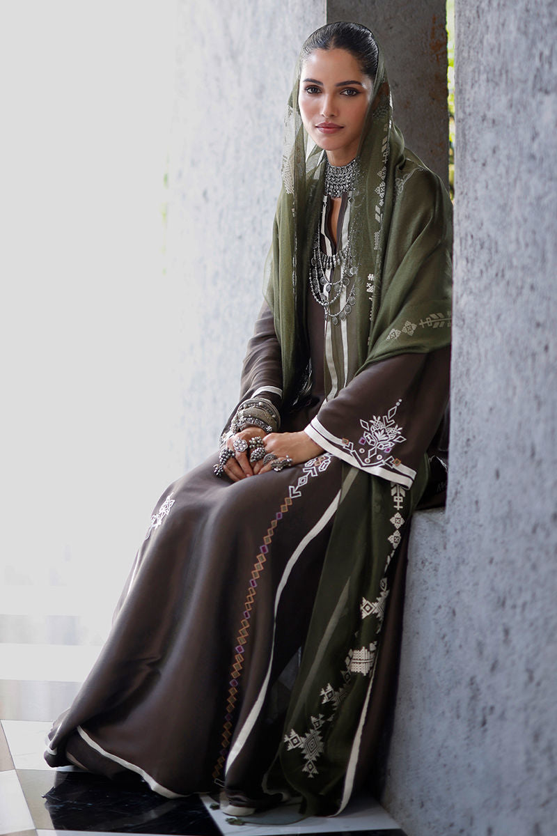 Woman wearing an embroidered abaya in a neutral setting