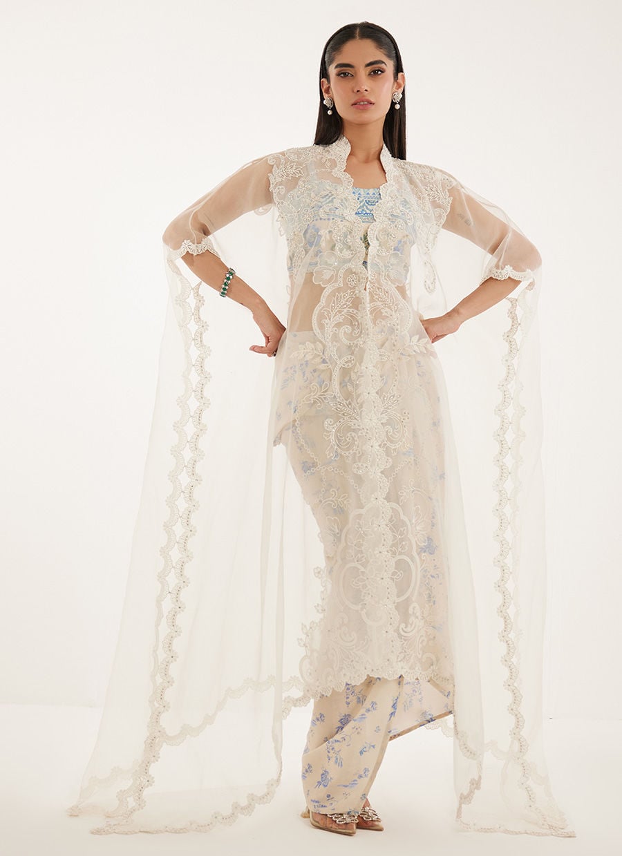 Woman wearing a traditional outfit with a sheer dupatta on a white background