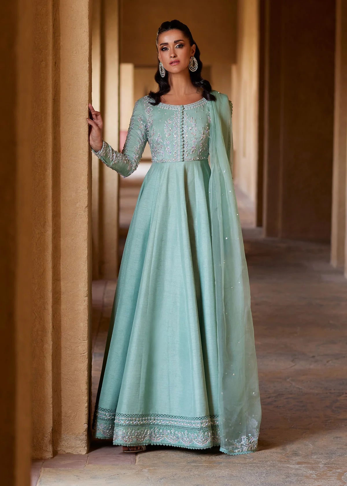 Woman wearing a light green embroidered dress in an indoor setting