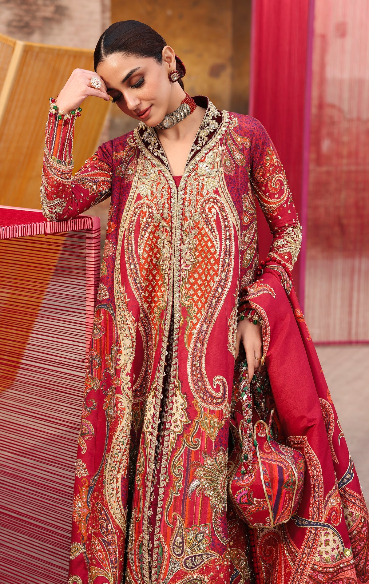Woman wearing a red and gold embroidered traditional outfit with a blurred background