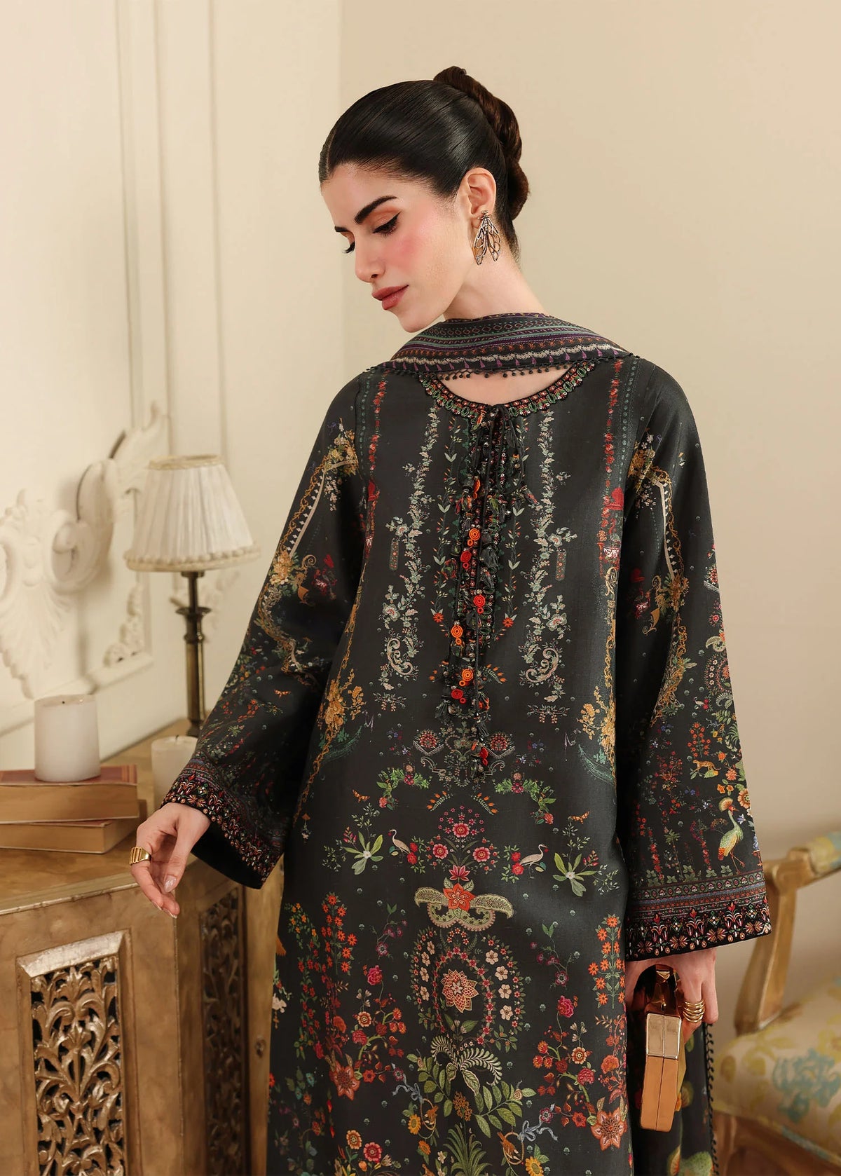 Woman wearing a dark floral dress in an elegant room setting.