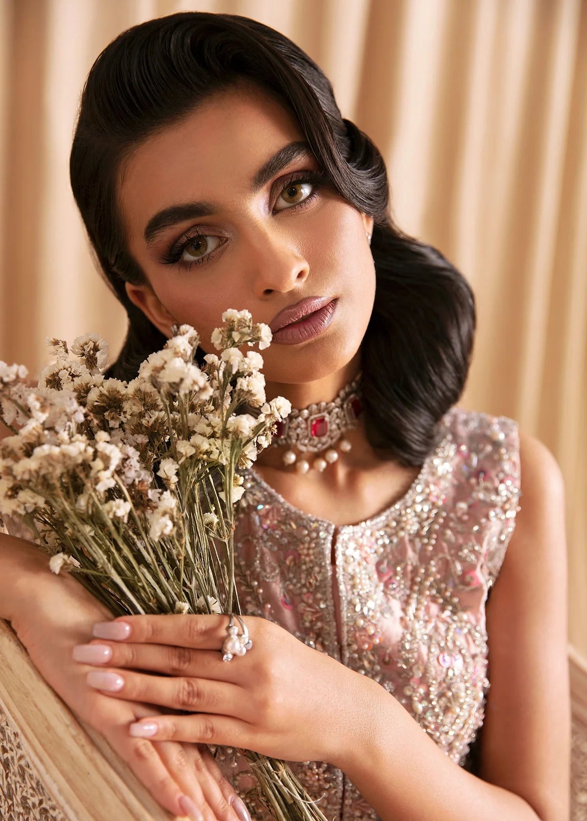 Woman holding a bouquet of flowers with a neutral background