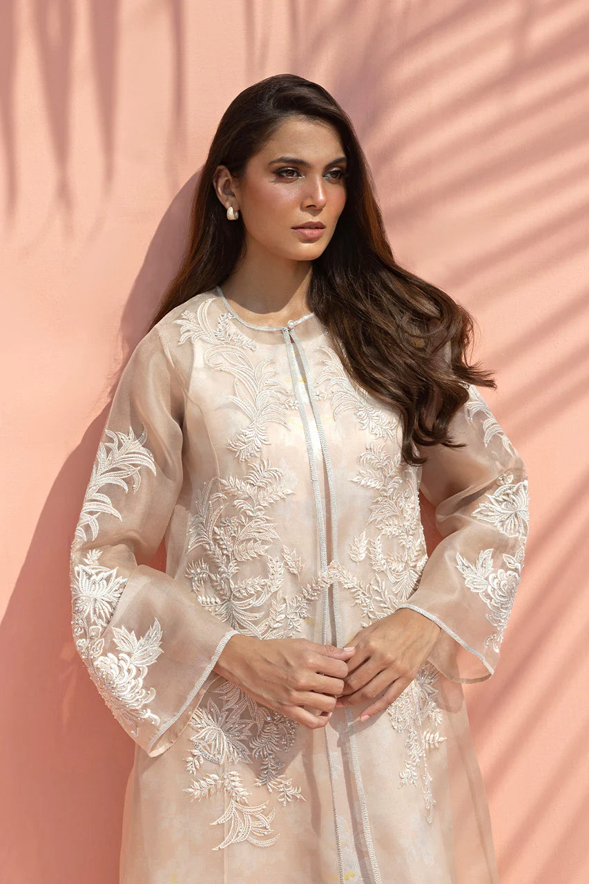 Woman wearing a white embroidered traditional outfit against a pink background
