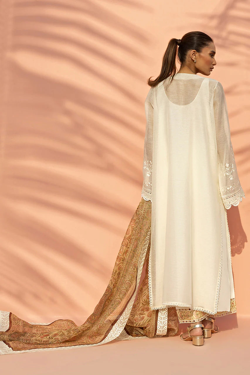 Woman in a white and gold traditional outfit against a pink background