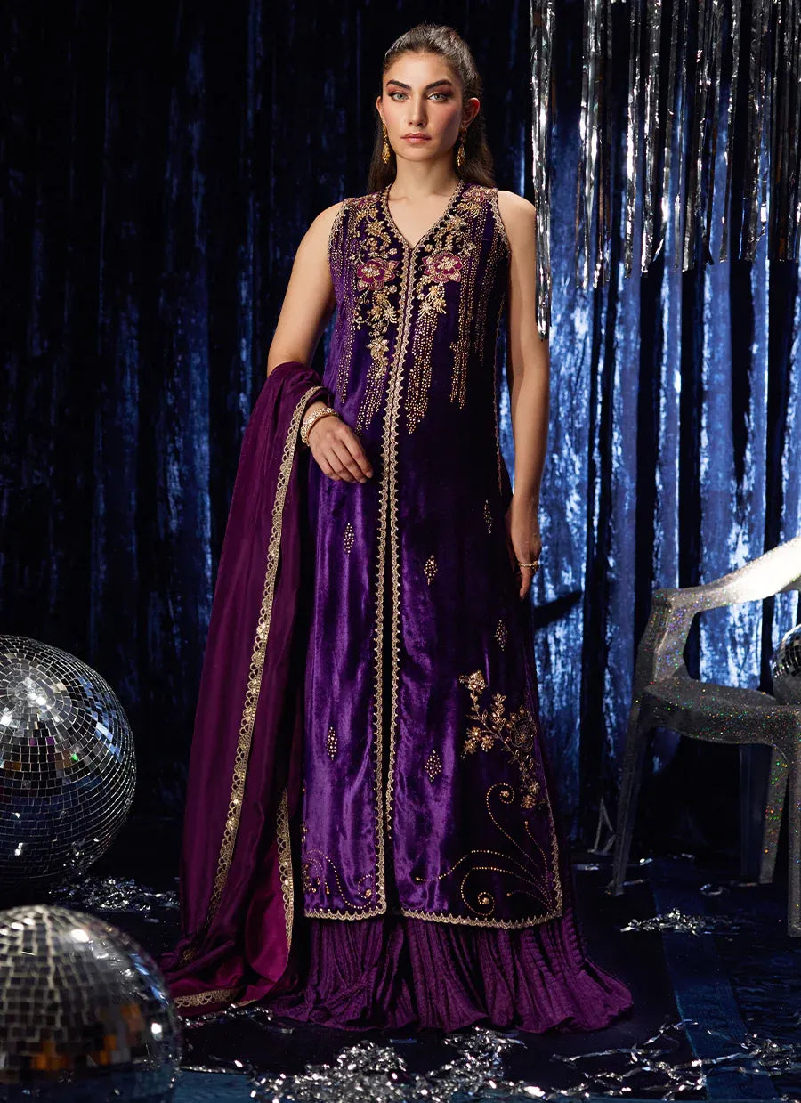 Woman in a purple embroidered traditional outfit with a blue curtain background