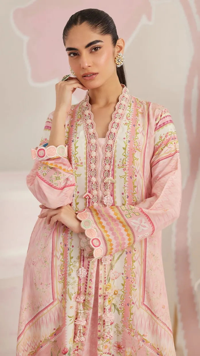 Woman wearing a pink embroidered traditional outfit with a soft pink background