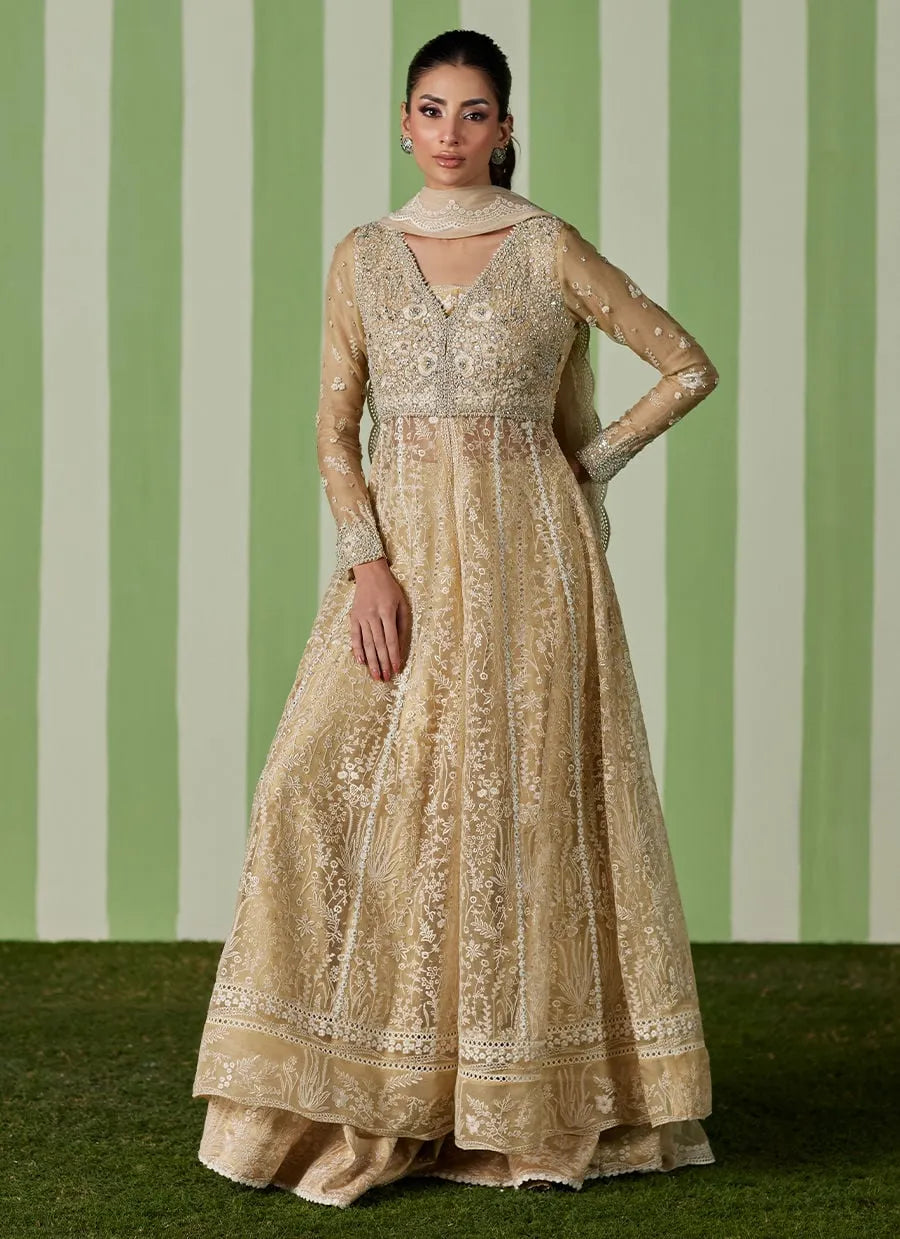 Woman wearing a beige embroidered traditional outfit against a green and white striped background