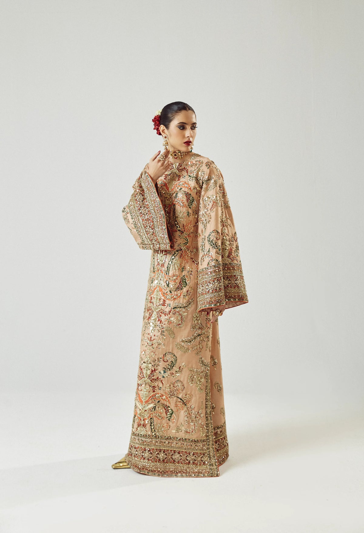 Woman wearing a traditional embroidered outfit on a white background