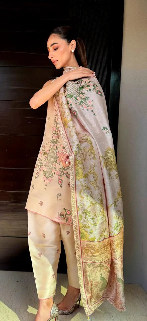 Woman wearing a floral dupatta and light-colored pants indoors.