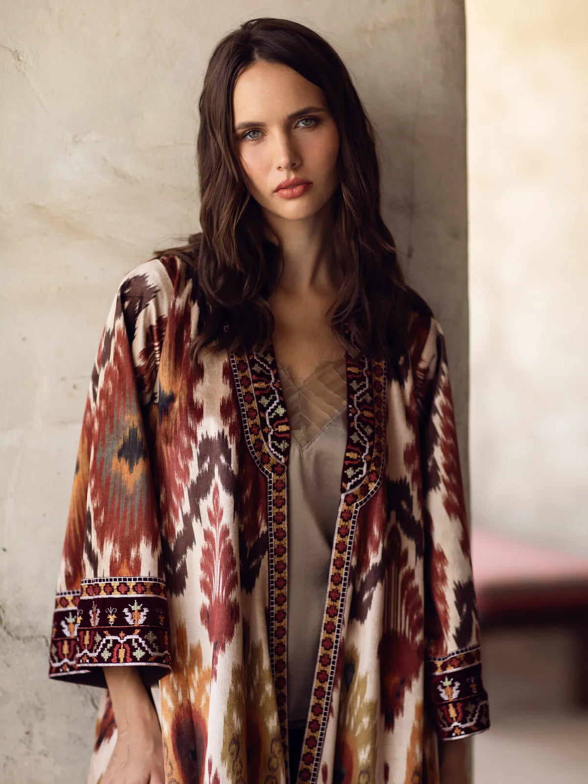 Woman wearing a patterned coat against a neutral background