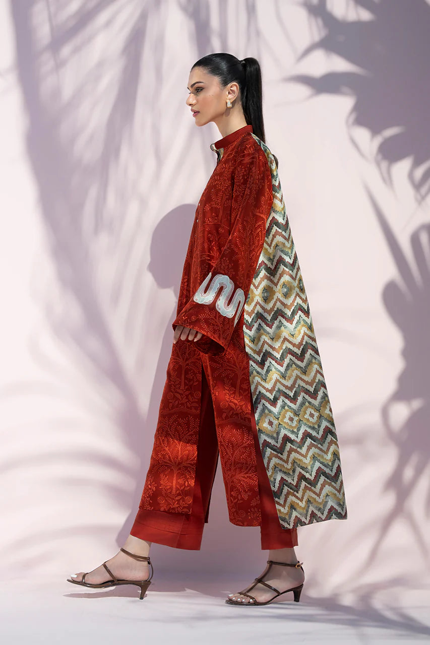 Woman in a red outfit with a colorful patterned scarf against a white background