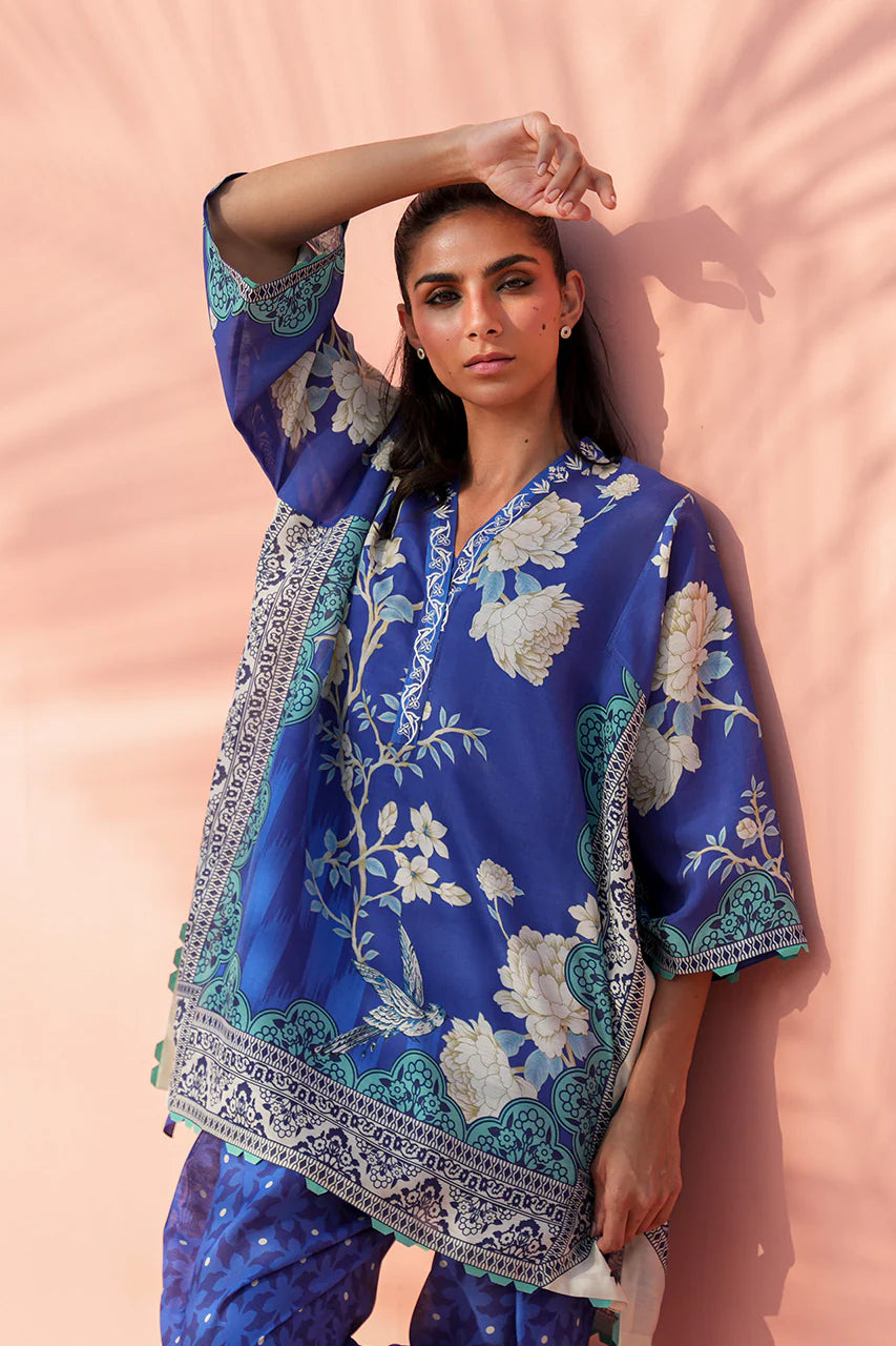 Woman wearing a blue floral dress against a pink background