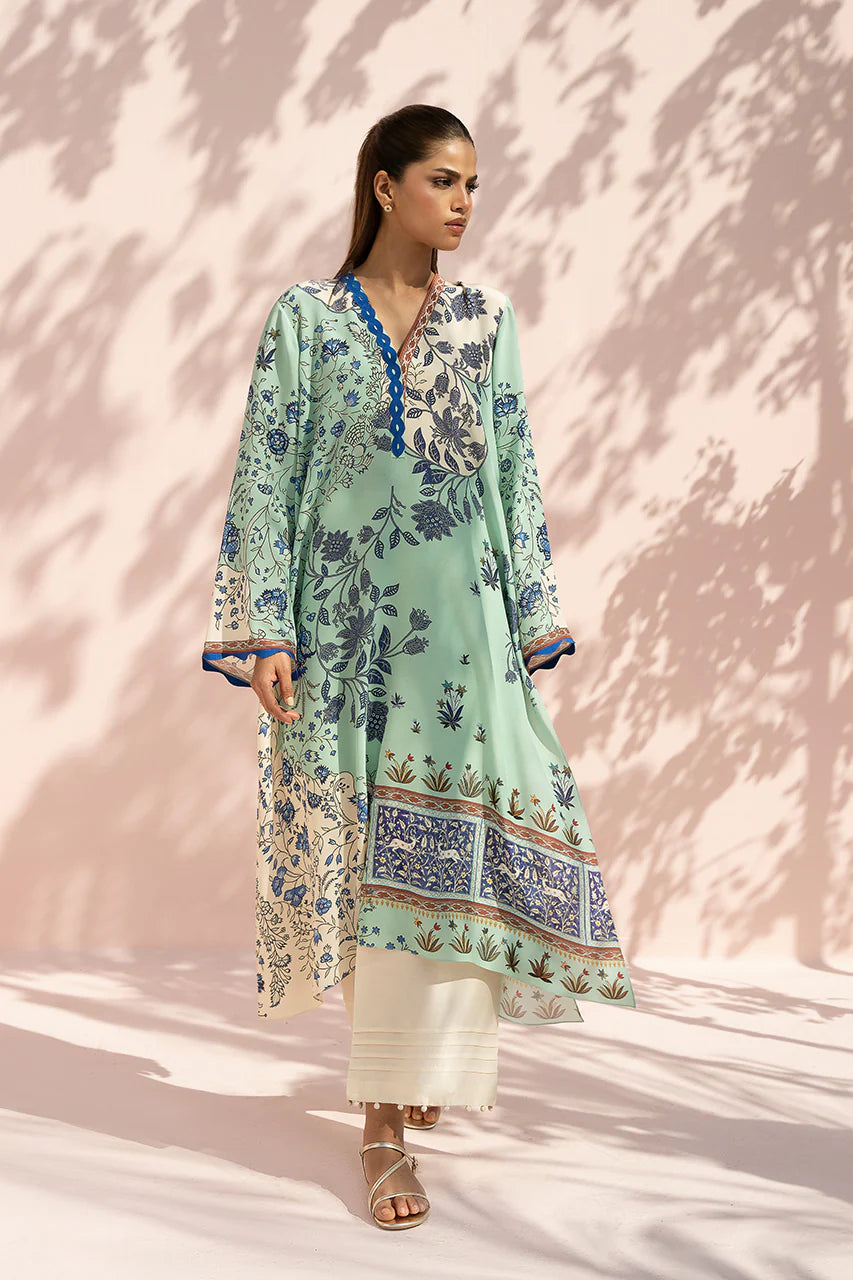 Woman wearing a light green floral dress with a pink background