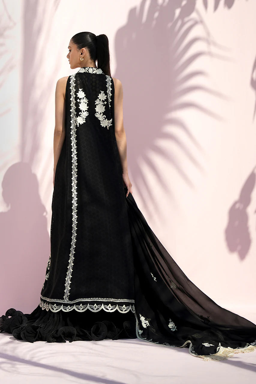 Black evening gown with white floral embroidery on a pink background