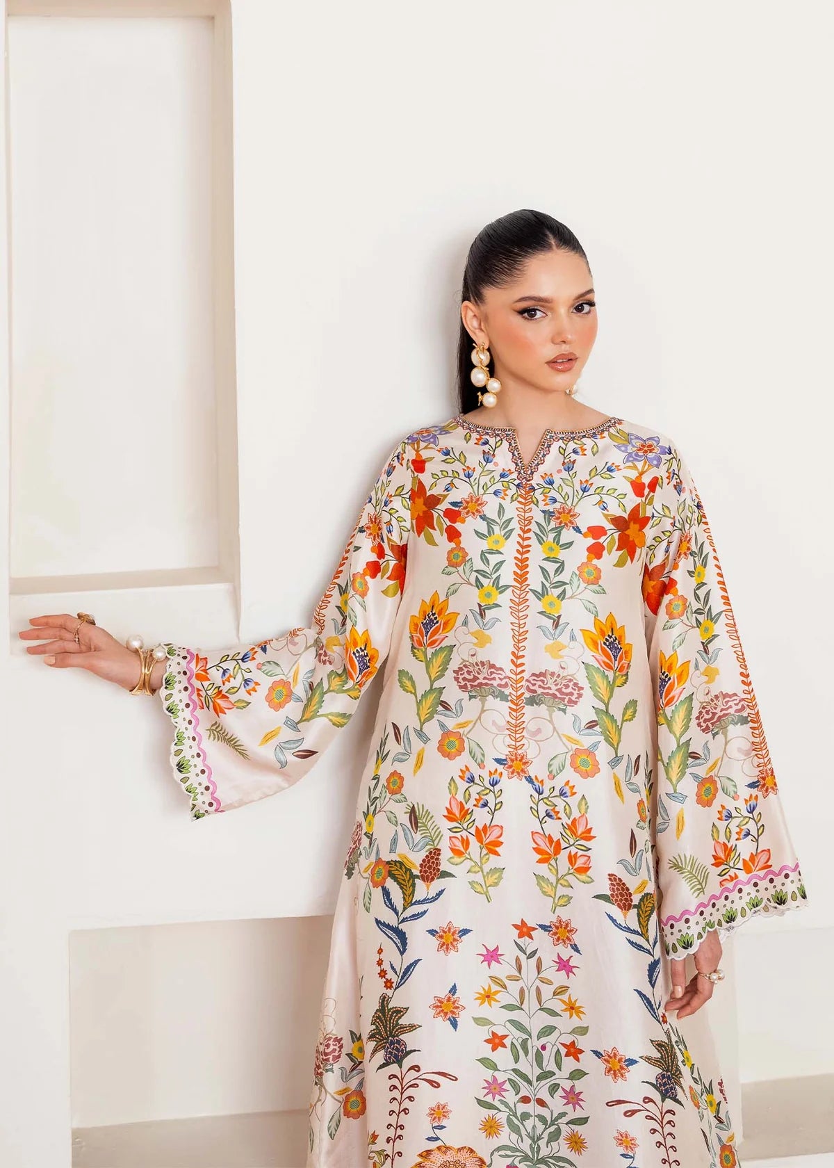 Woman wearing a floral embroidered outfit against a white background