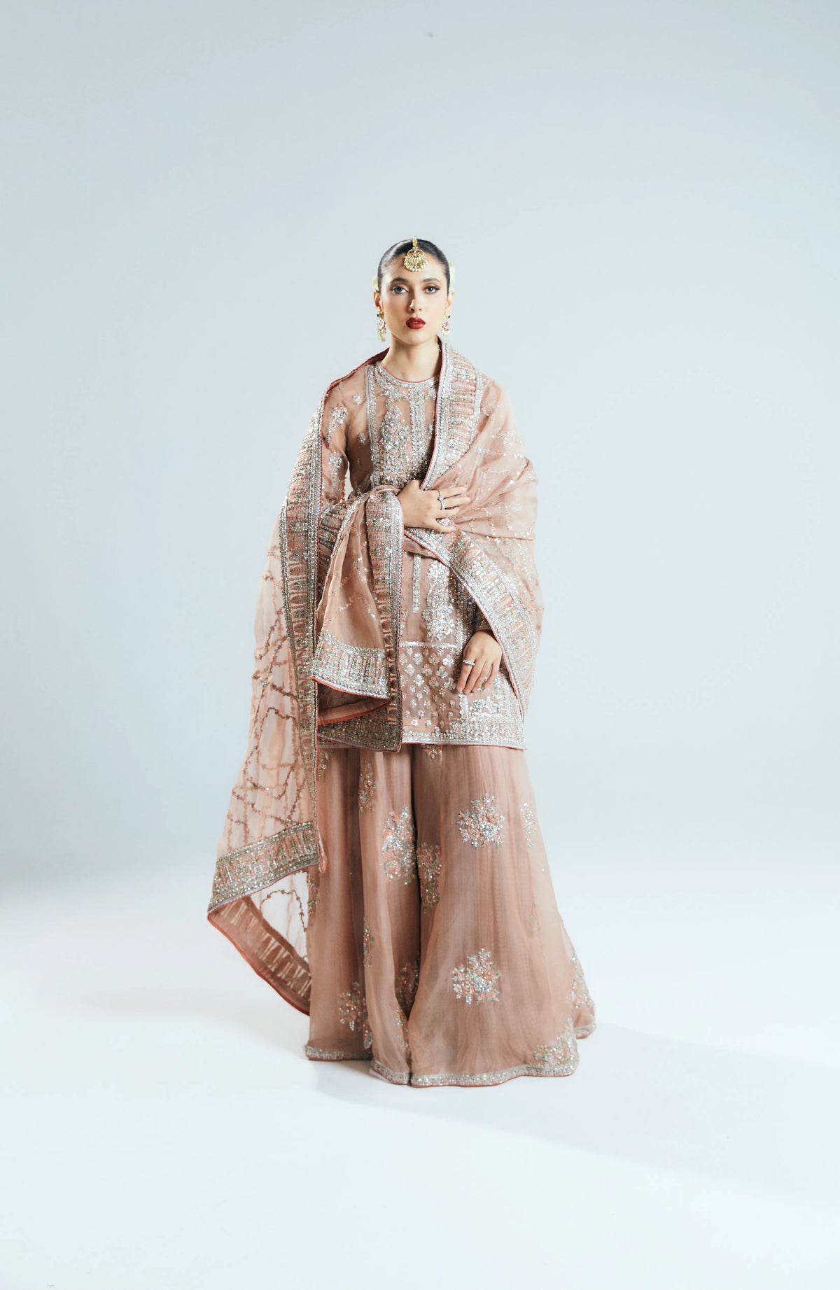Woman wearing a traditional outfit with a shawl on a white background