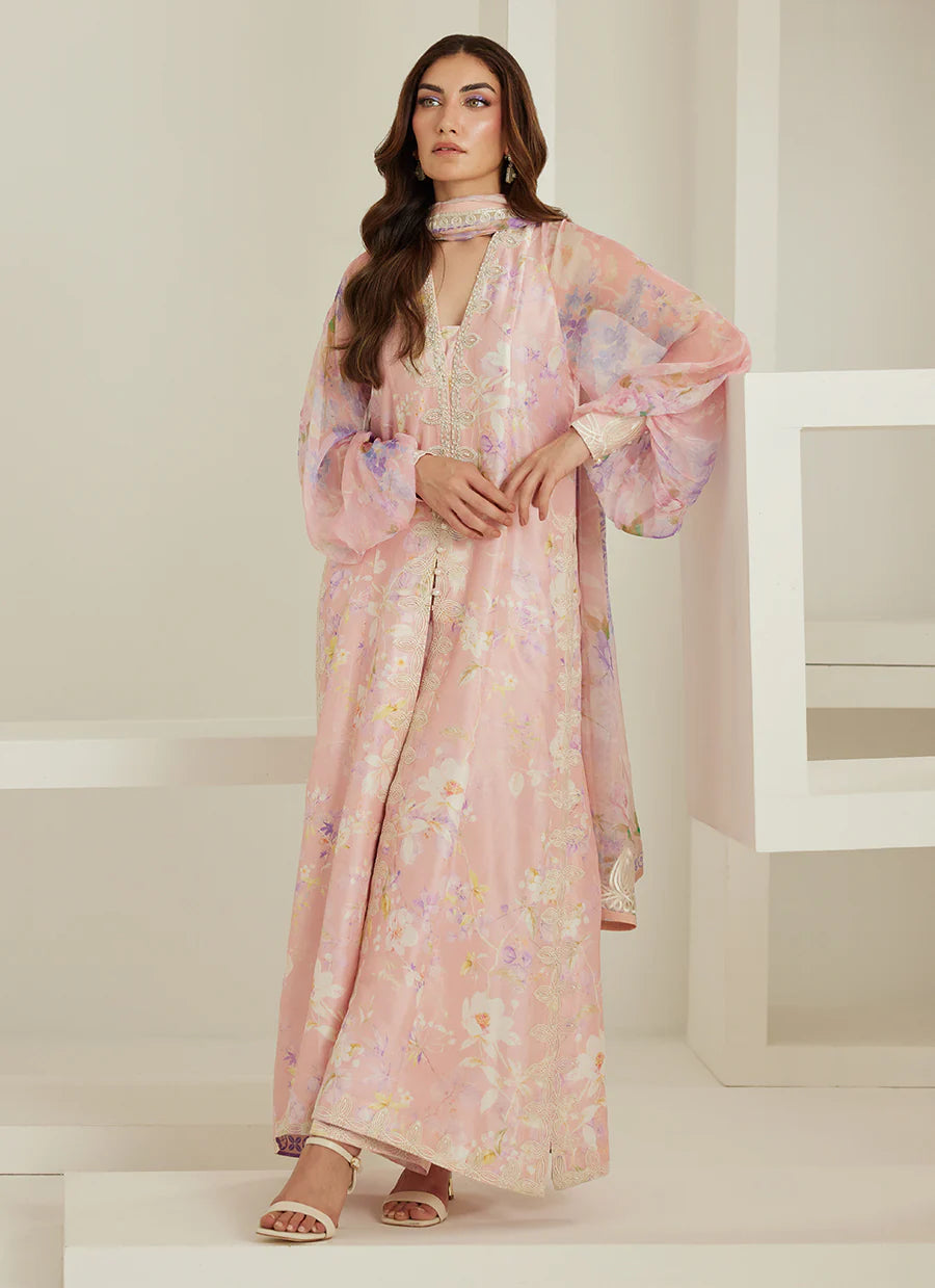 Woman wearing a pink floral dress in a minimal white setting