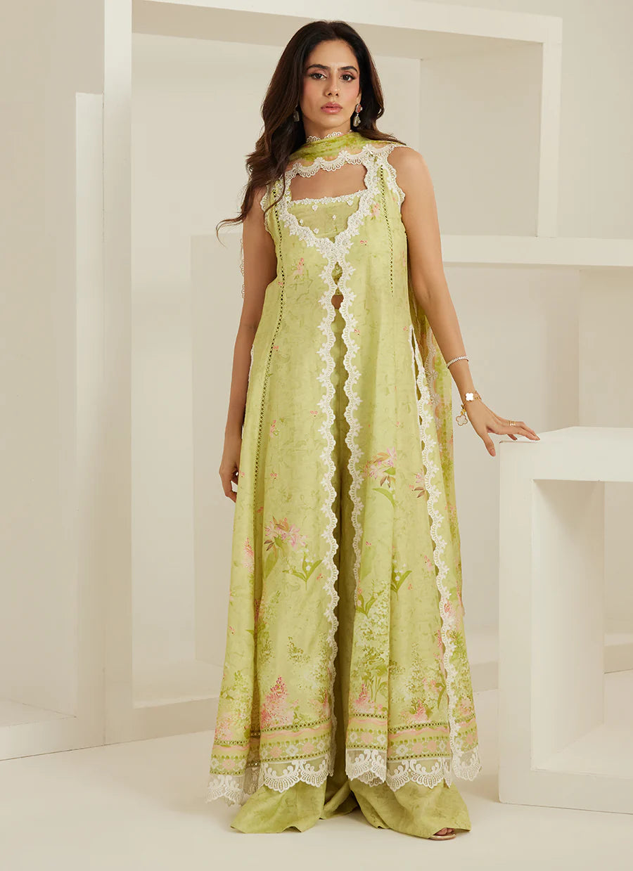 Woman wearing a light green traditional outfit with floral patterns in a minimalistic setting