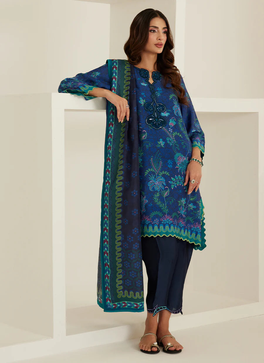 Woman wearing a blue embroidered outfit with a white background