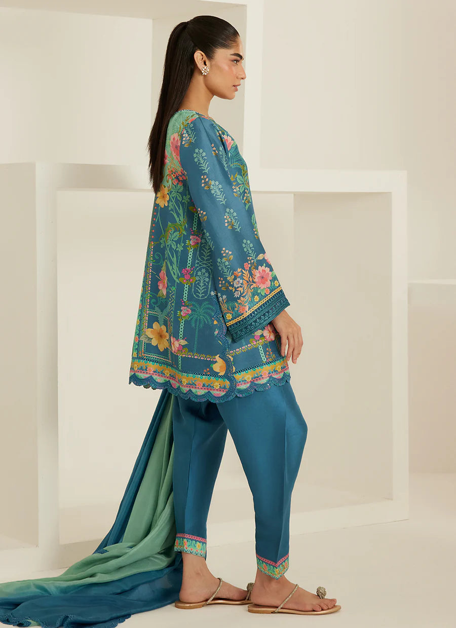 Woman wearing a teal embroidered outfit with a matching dupatta against a white background