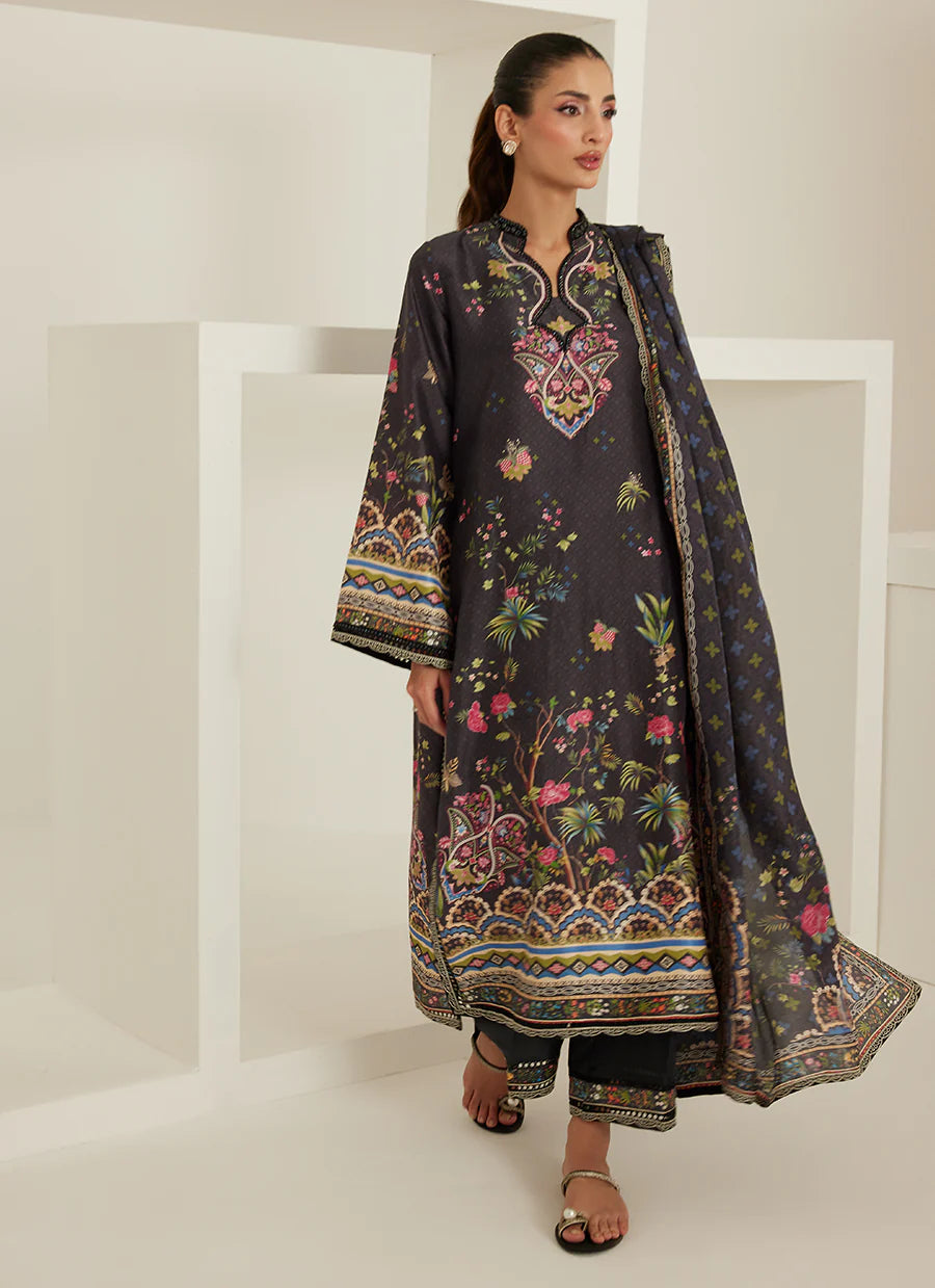 Woman wearing a dark floral embroidered outfit with a matching dupatta against a white background