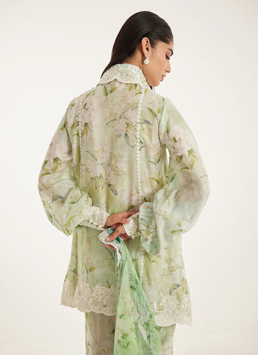 Woman wearing a light green floral outfit on a white background