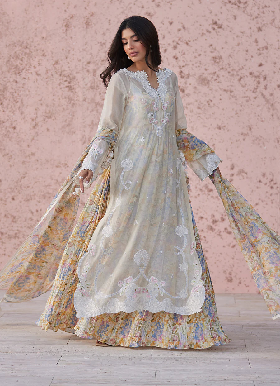Woman wearing a floral embroidered dress with a soft pink background