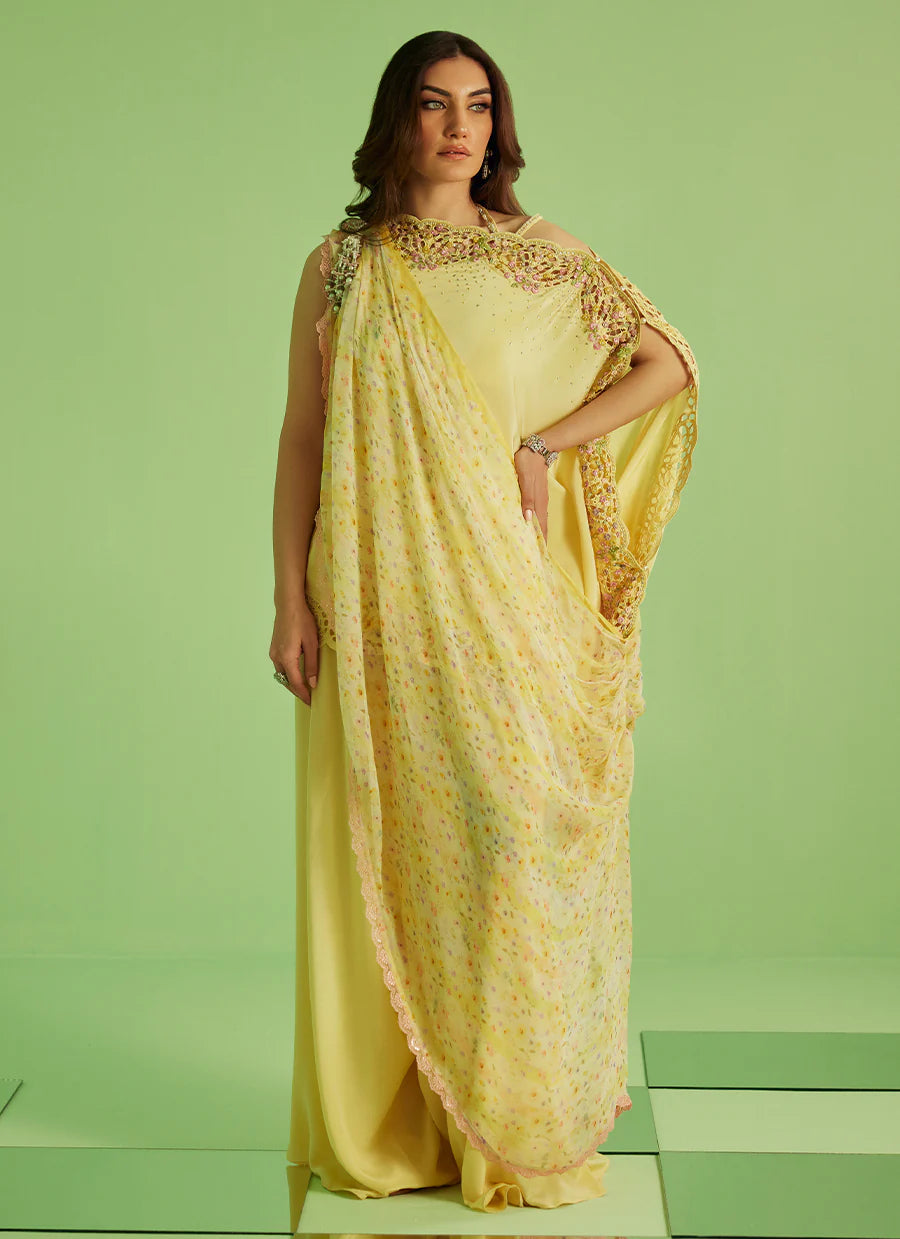 Woman wearing a yellow saree with a green background