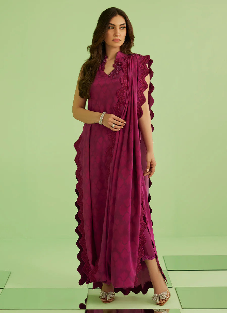 Woman wearing a magenta saree with a green background