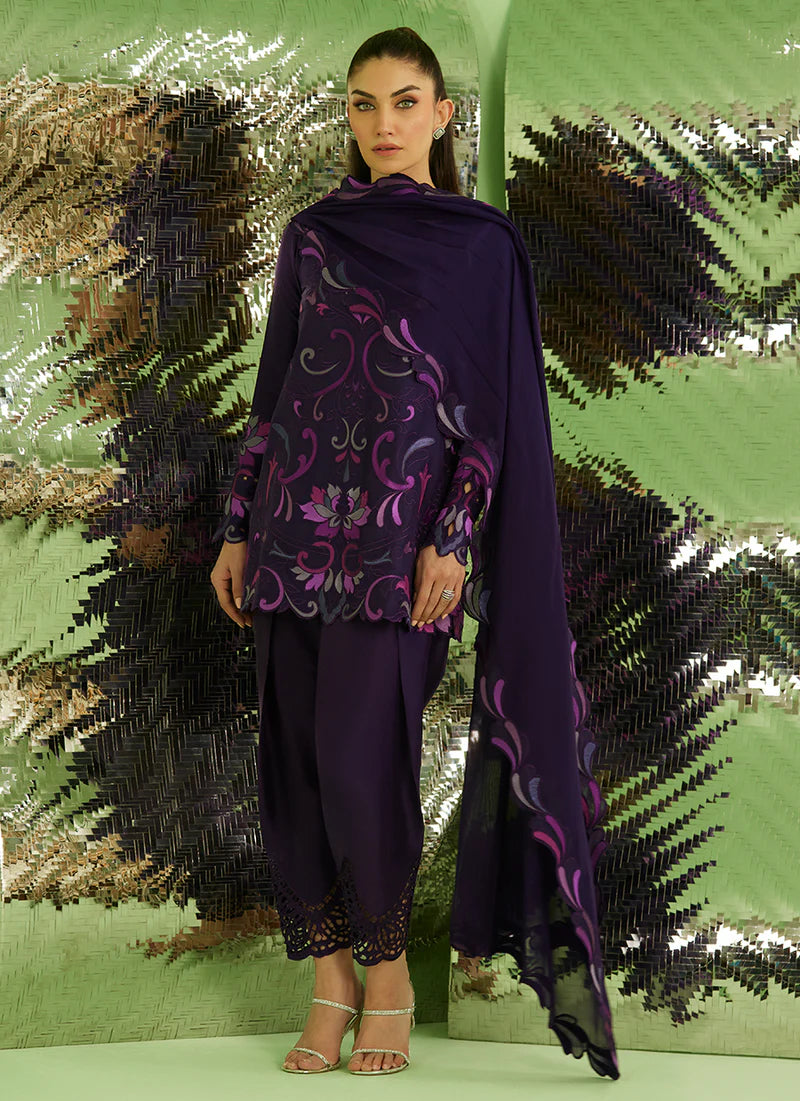 Woman wearing a purple outfit with floral patterns against a green and black sequined background