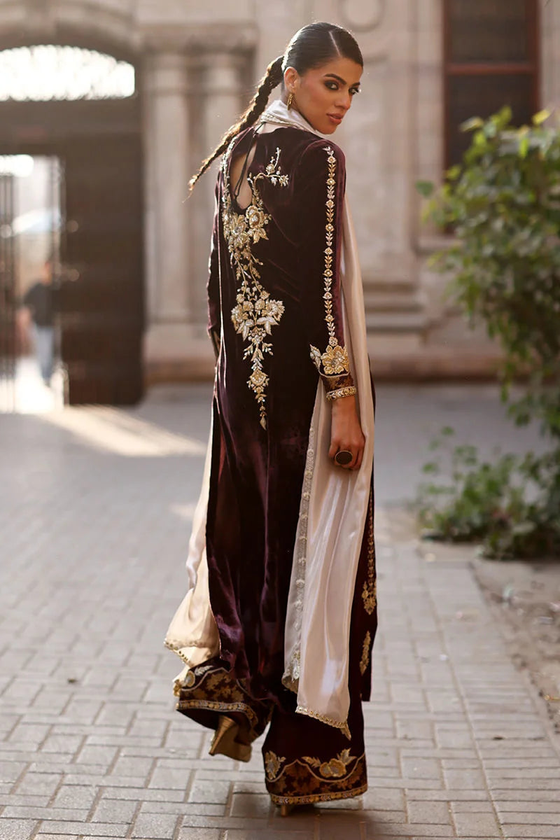 Woman in traditional outfit with floral patterns walking outdoors.