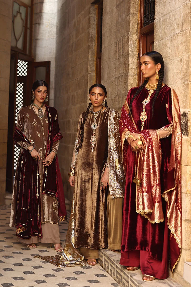 Three women in traditional attire standing in a sunlit hallway.