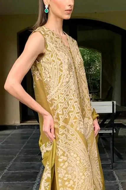 Woman wearing a gold and white patterned outfit with a matching shawl outdoors.