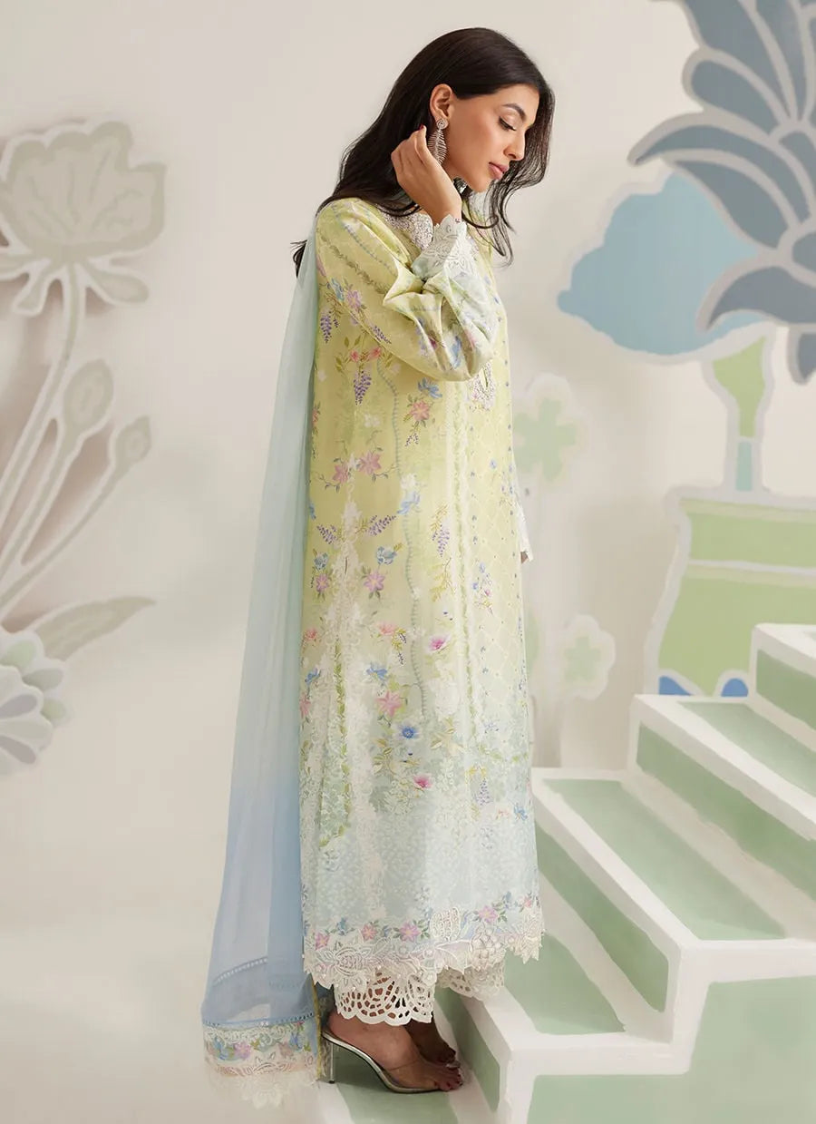 Woman in a light-colored traditional outfit with floral patterns standing on a staircase.
