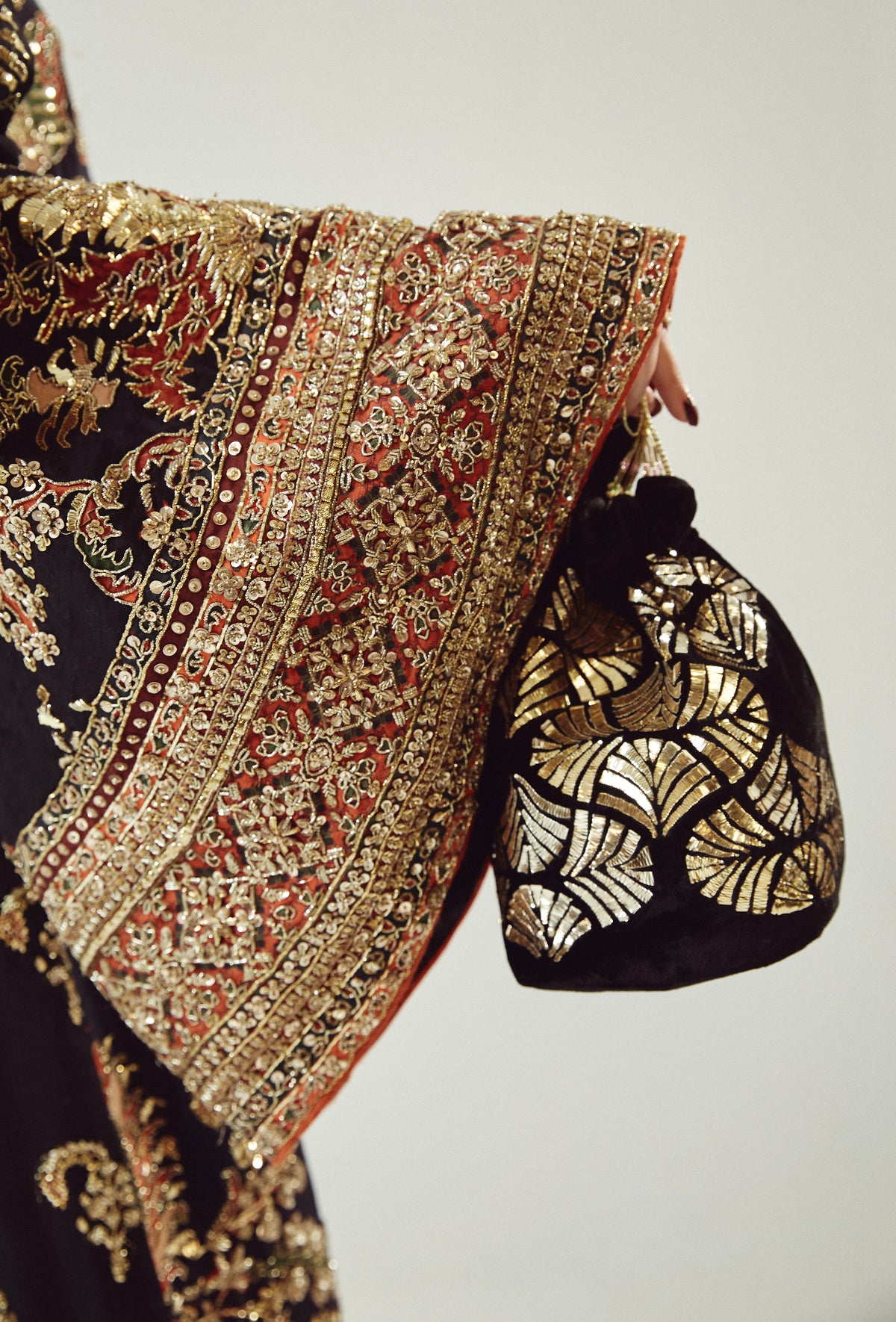 Traditional embroidered fabric with a matching potli bag on a plain background