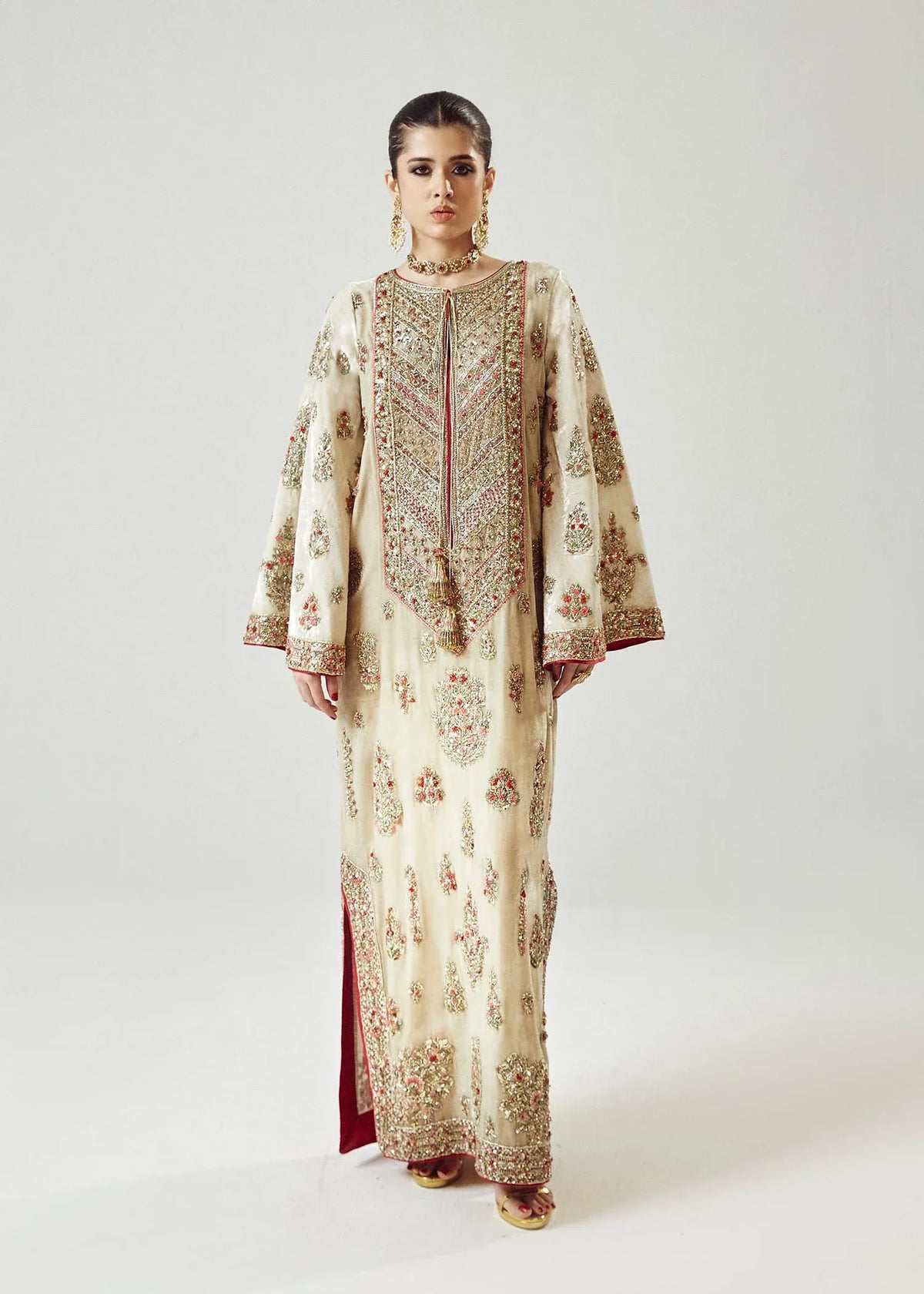 Woman wearing a traditional embroidered outfit on a white background