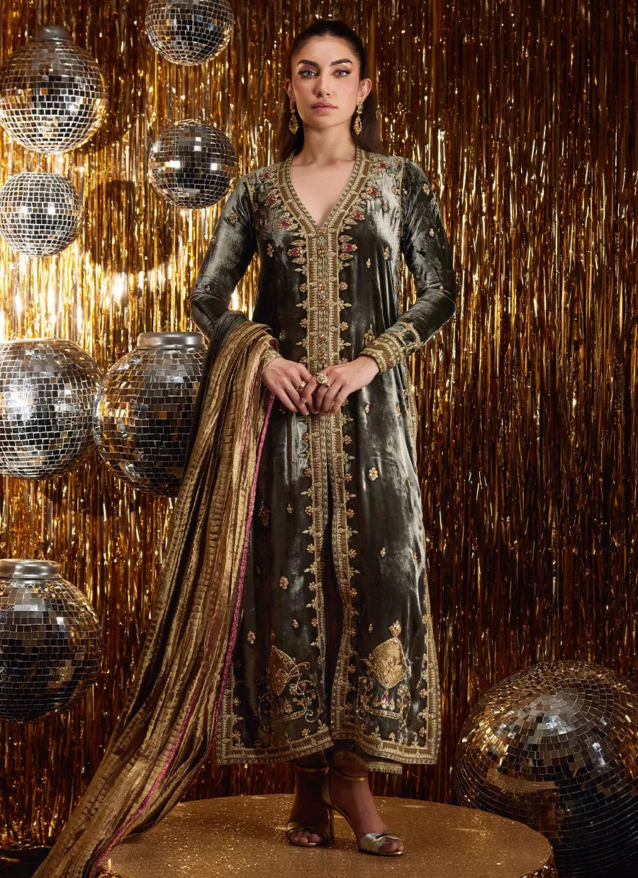 Woman in an ornate dress standing in front of disco balls and a gold curtain
