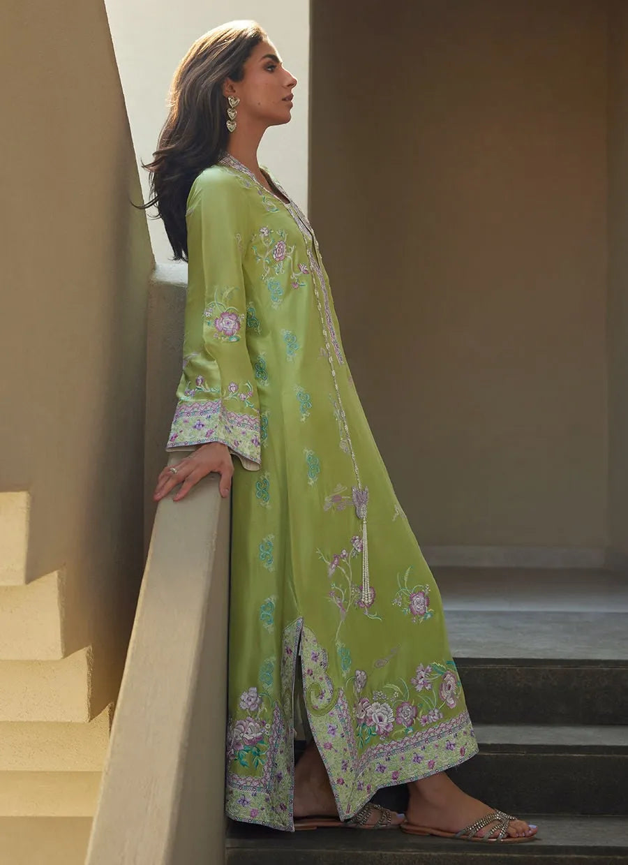 Woman in a green floral dress standing on a staircase