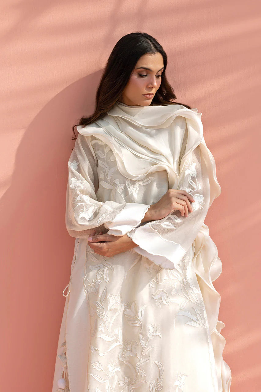 Woman wearing a white dress against a pink background