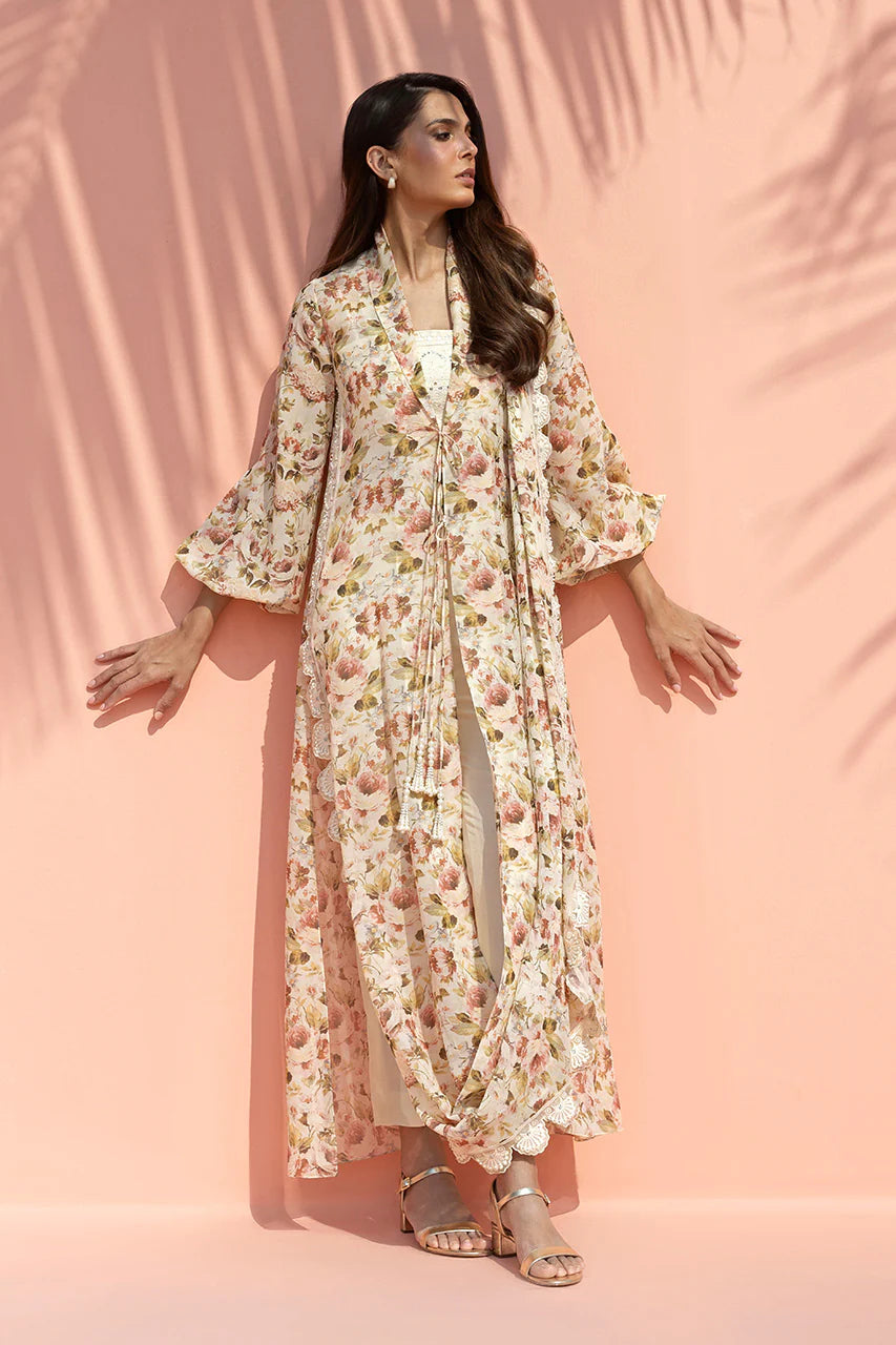 Woman wearing a floral dress and jacket against a pink background