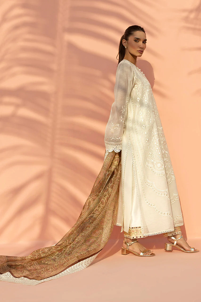 Woman wearing a traditional outfit with a long, flowing fabric against a pink background
