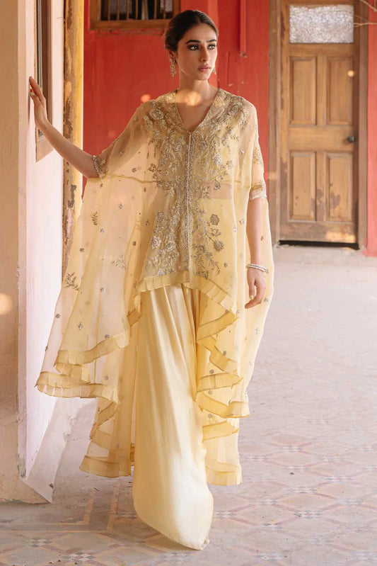 Woman in a traditional outfit with intricate designs in a decorated interior setting