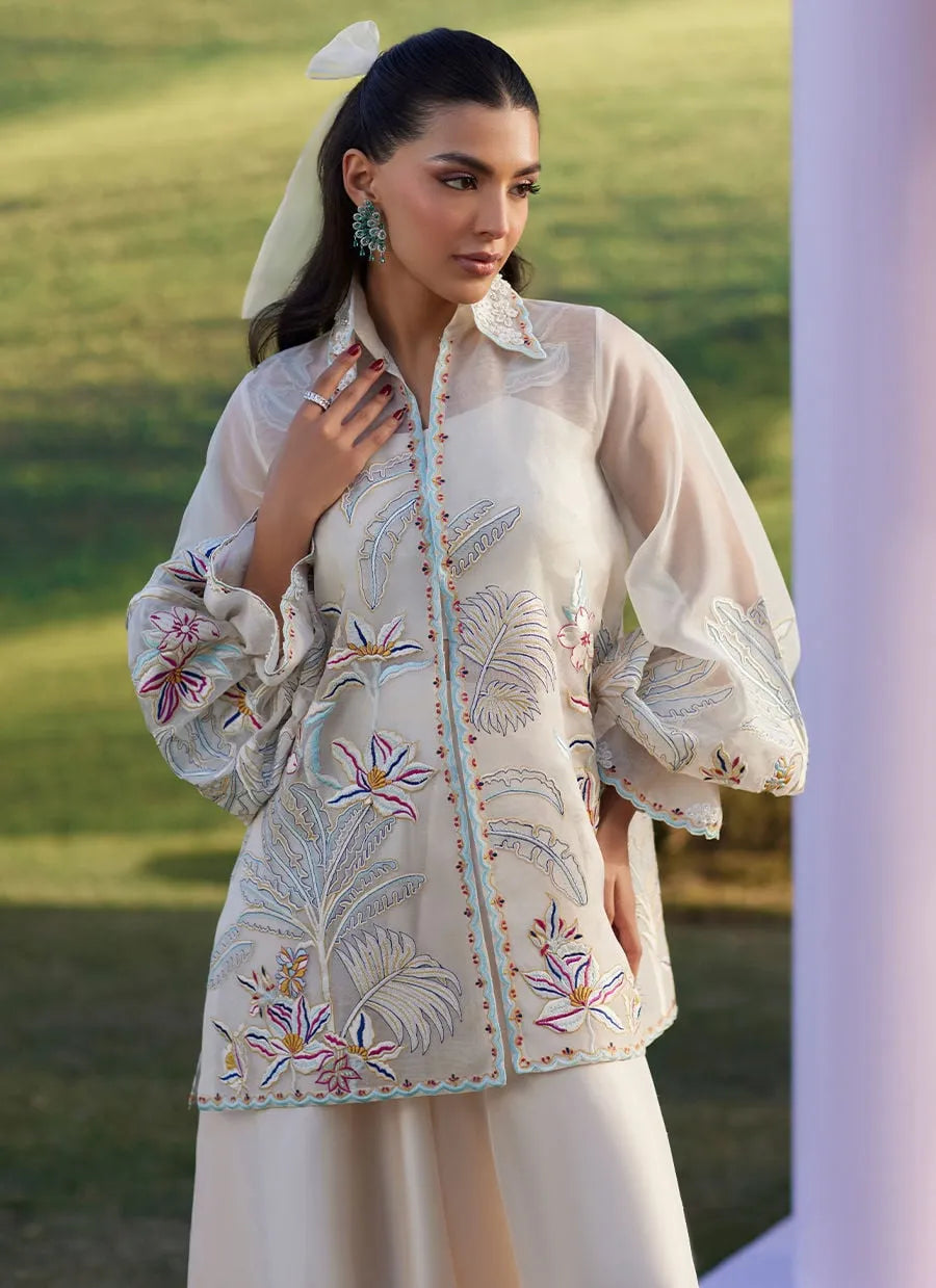 Woman wearing an embroidered traditional outfit with a scenic background