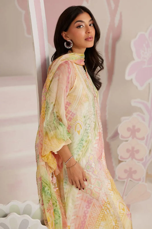 Woman wearing a colorful floral dress with a soft pink background