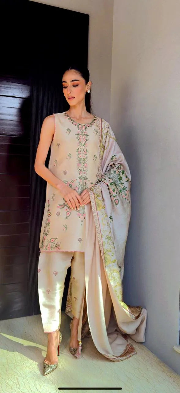 Woman in a traditional outfit with floral patterns indoors.