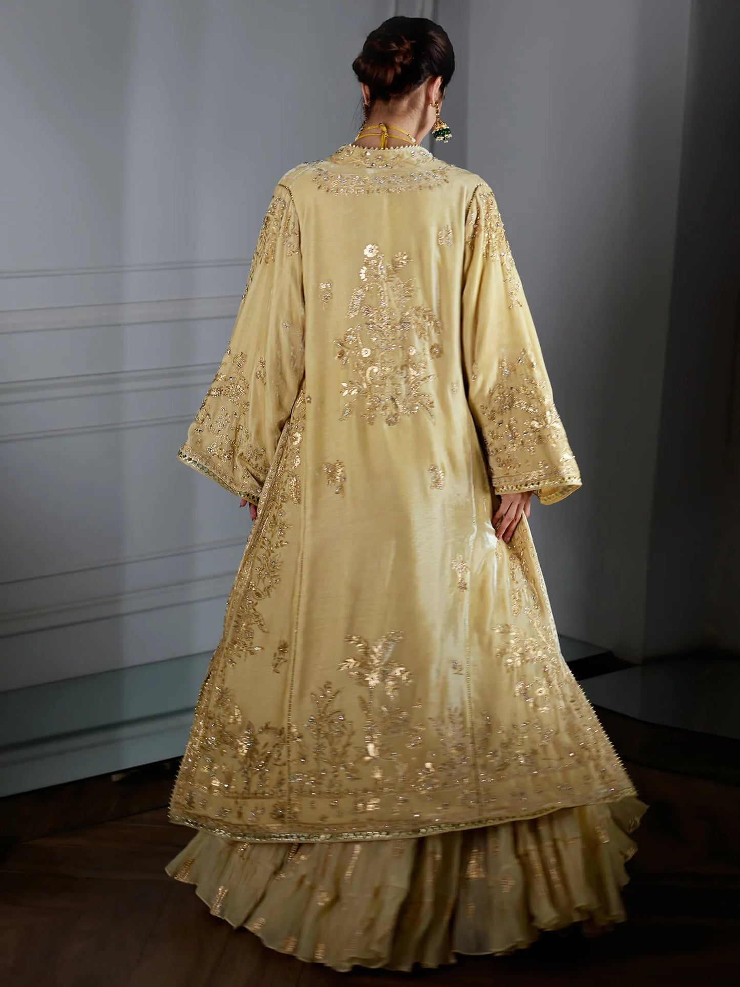Beige embroidered traditional outfit with a plain background