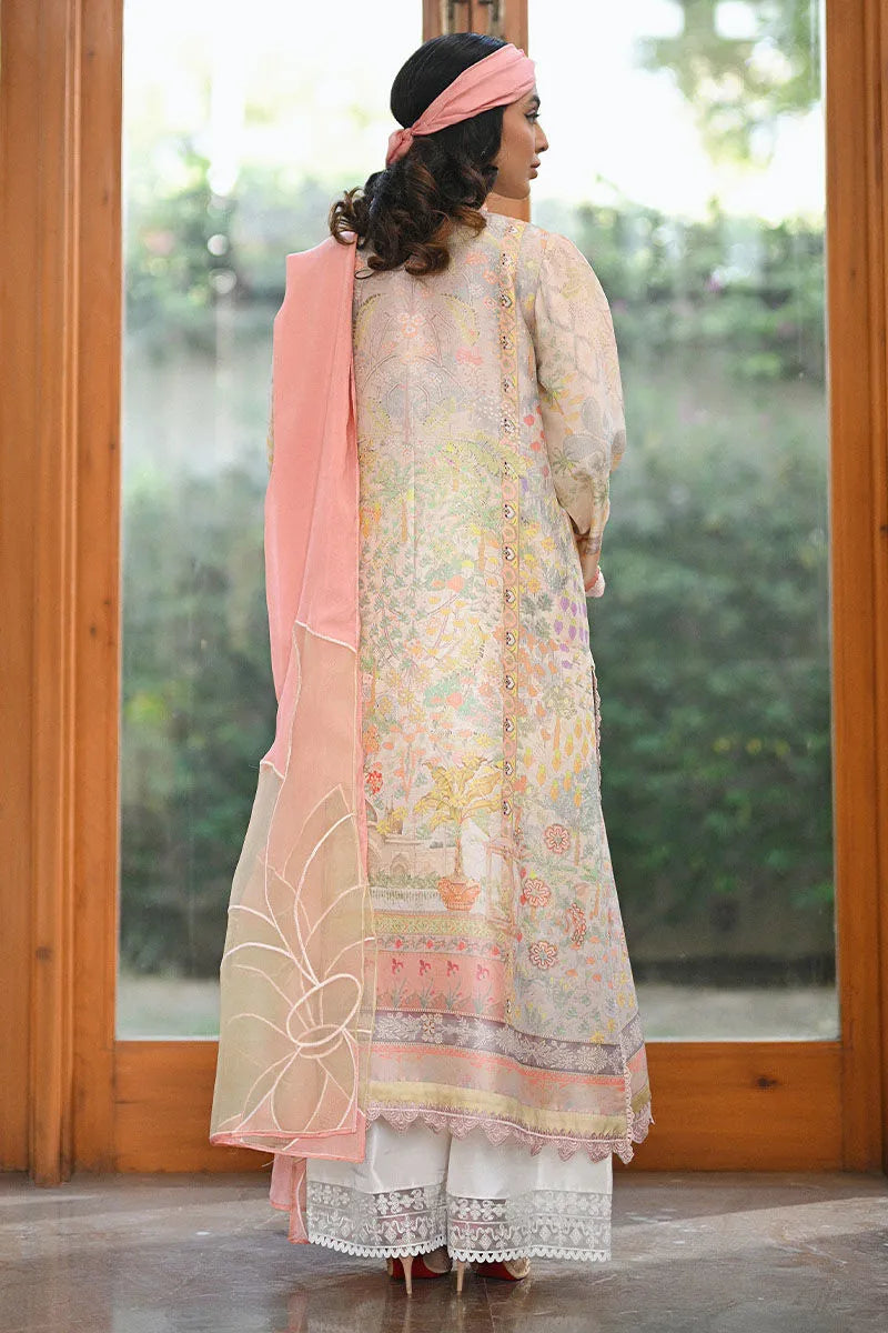 Woman wearing a floral dress with a pink dupatta standing in front of a glass door.