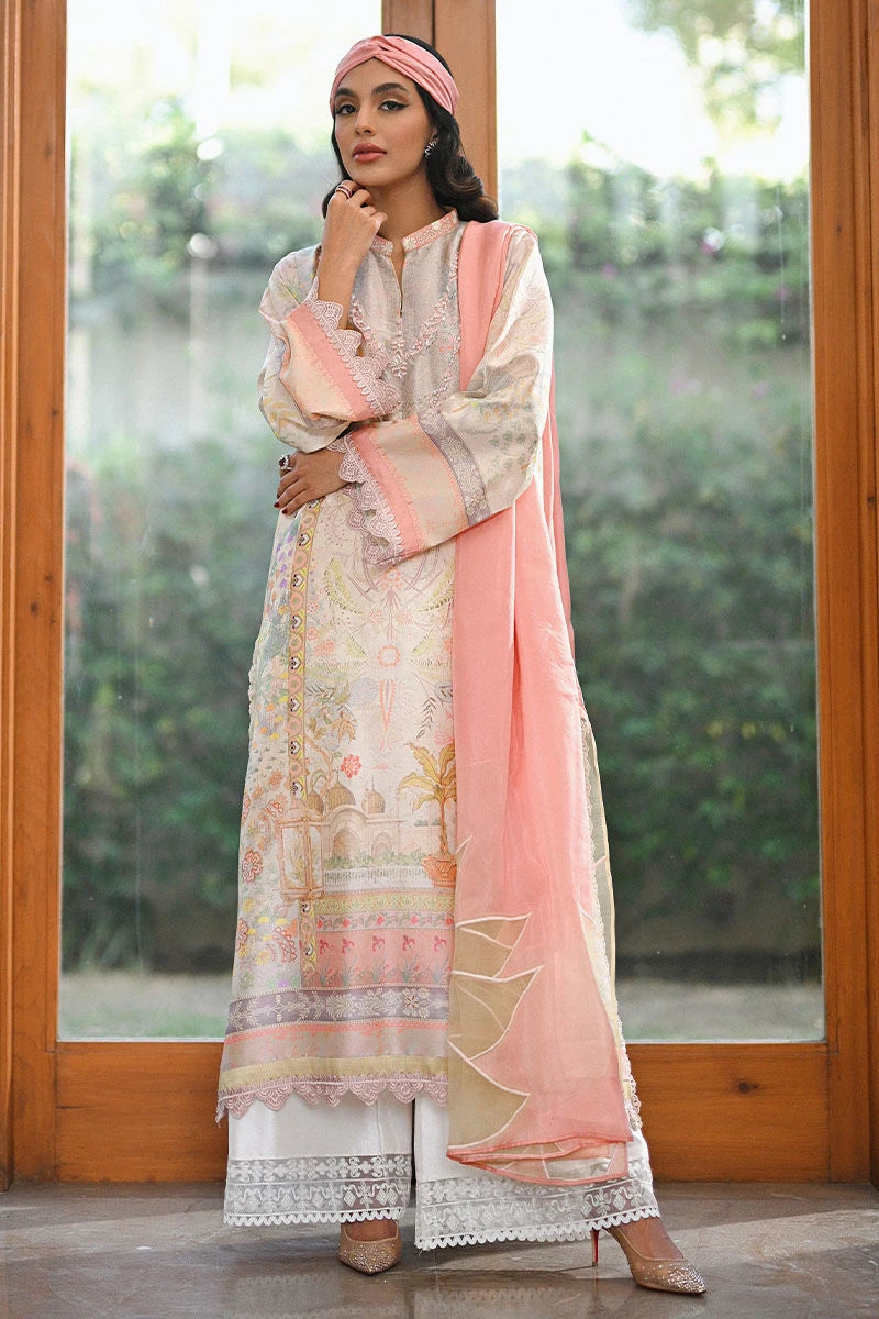 Woman in traditional outfit with pink dupatta standing indoors.