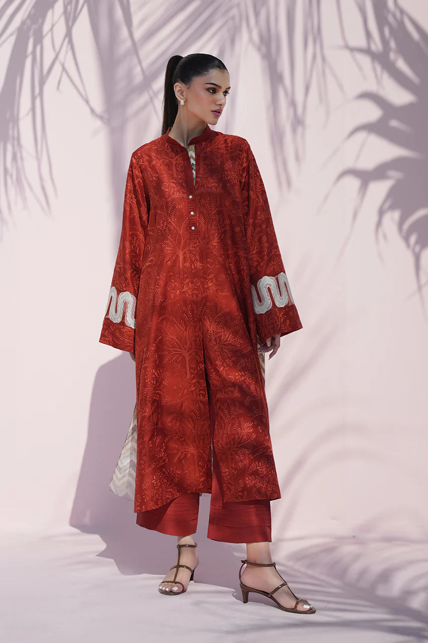 Woman wearing a red traditional outfit with white patterns against a white background